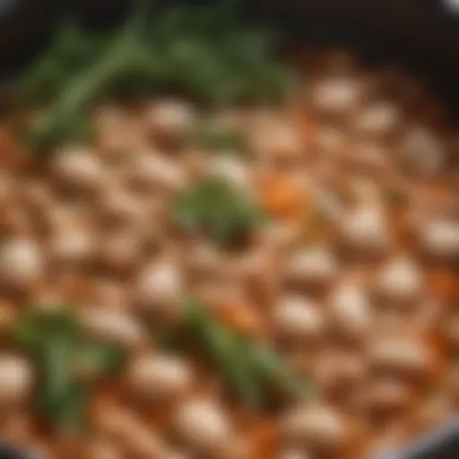 A pot of simmering white beans with aromatic herbs